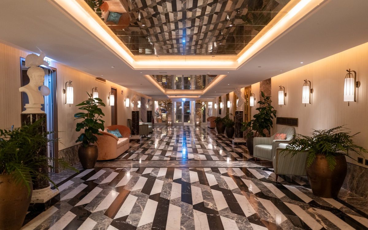 Hall d’hôtel avec marbre, fauteuils et plantes
